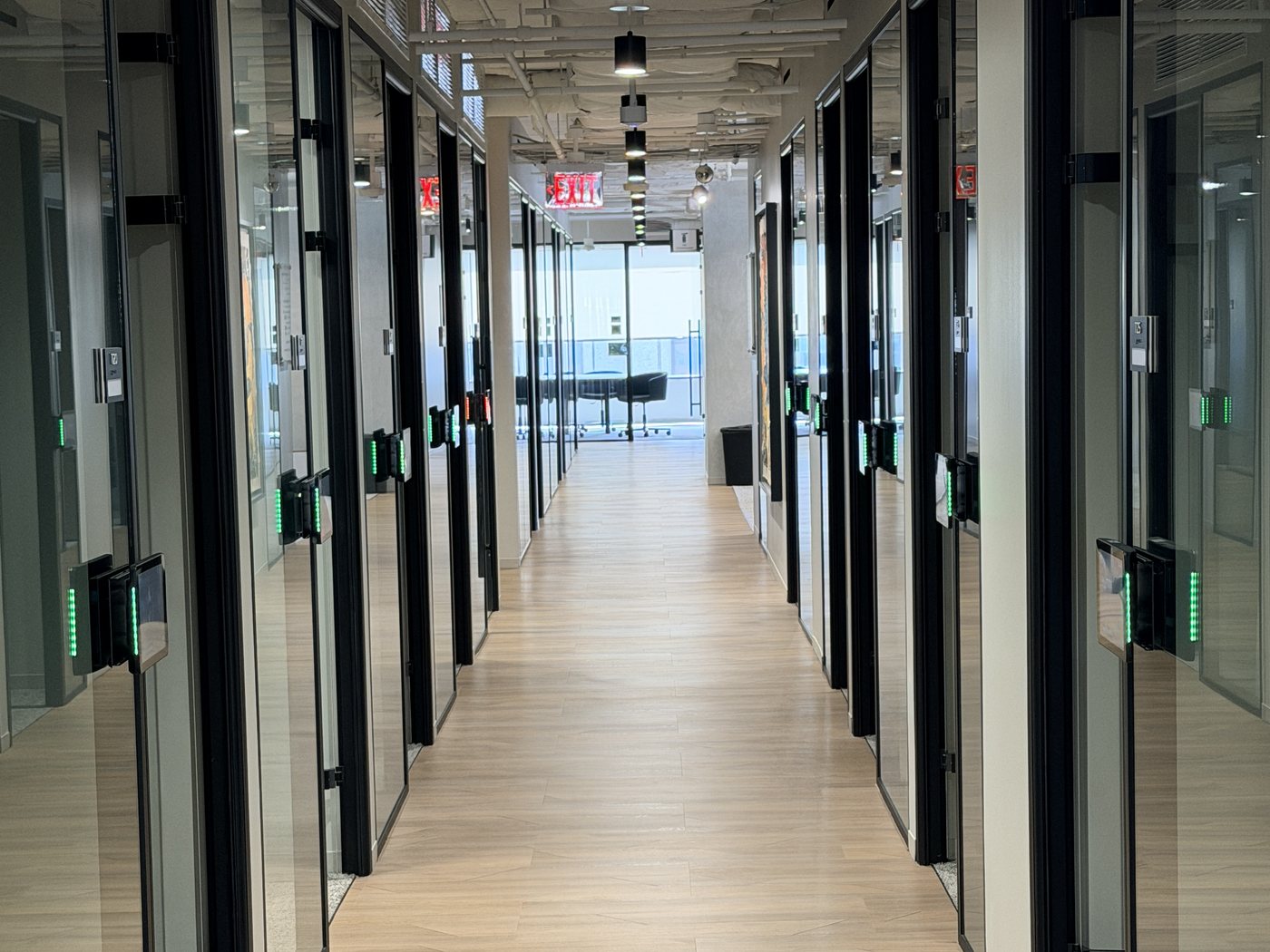 A corridor at the Nakupuna Arlington office lined with room displays, their LED status bars showing green and red down both sides